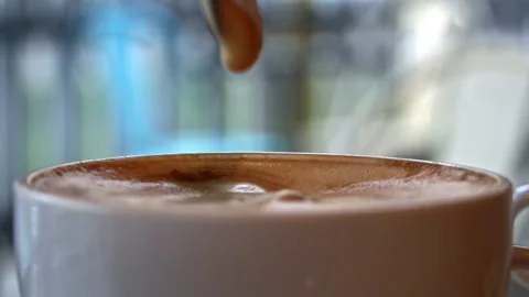 Cup of Coffee Stands on a Table in a Coffee Shop and is Stirred with a Spoon Stockbeeldmateriaal 229531855