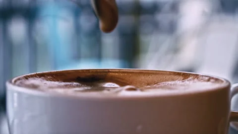 Cup of Coffee Stands on a Table in a Coffee Shop and is Stirred with a Spoon Stock Footage 229764442