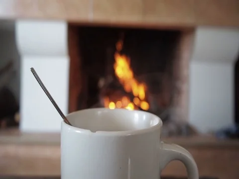 A cup of coffee steaming in front of the fireplace Stock Footage 102230711