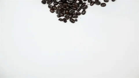 A cup of coffee surrounded by coffee beans on white background. Stock Footage 100790890