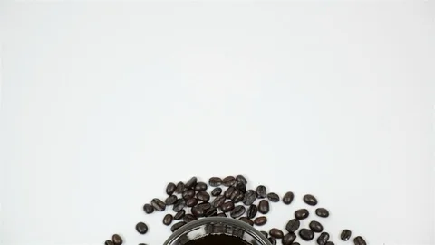 A cup of coffee surrounded by coffee beans on white background. Stock Footage 100791486