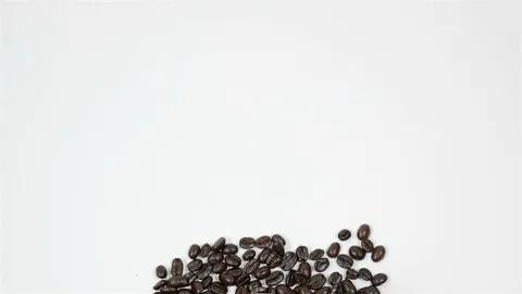 A cup of coffee surrounded by coffee beans on white background. Stock Footage 100794768
