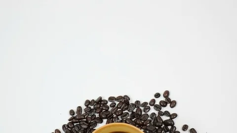 A cup of coffee surrounded by coffee beans on white background. Stock Footage 100795266