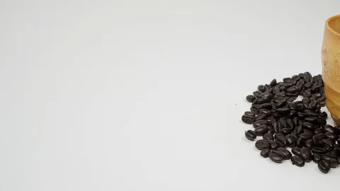 A cup of coffee surrounded by coffee beans on white background. Stock Footage 100796225
