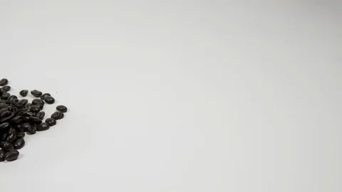 A cup of coffee surrounded by coffee beans on white background. Stock Footage 100796408