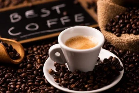 Cup of coffee surrounded by coffee beans Stock Photos