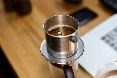 Cup of coffee on the table. brewing coffee using phin filter. it is traditional Stock Photos