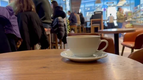 Cup of coffee on the table in cafe and visitors on background . Stock Footage 322073190