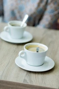 Cup of coffee on a table in a cafe close-up with shallow depth of field Stock Photos