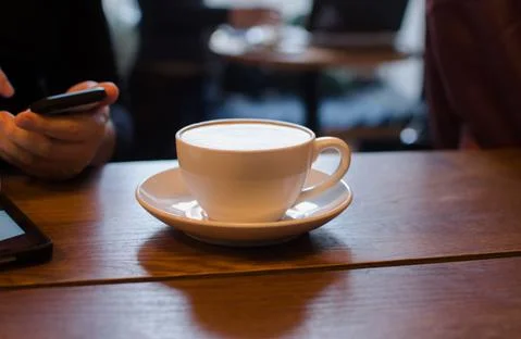 Cup of coffee on table in cafe Stock Photos