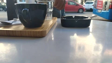 A cup of coffee on the table. A cigarette smokes in the ashtray Video stock 306575705