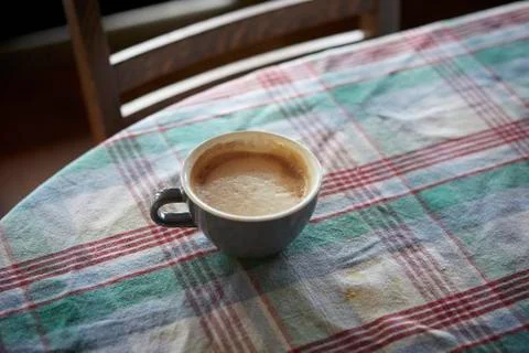 Cup of coffee on table covered with checkered cloth Stock Photos
