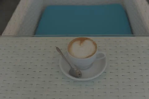 Cup of coffee on the table. Cup of coffee in a white cup on a white table. Stock Photos