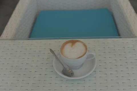 Cup of coffee on the table. Cup of coffee in a white cup on a white table. Stock Photos