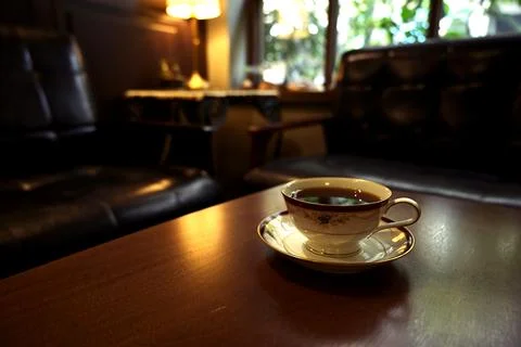 A cup of coffee on table in a dark coffee shop Stock Photos
