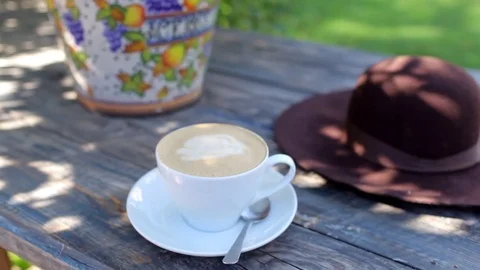 A cup of coffee on a table in the garden Stock Footage 81810313