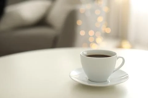 Cup of coffee on table indoors, space for text. Bokeh effect Stock Photos