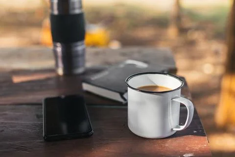 Cup of coffee on the table with the mobile and a thermos, Stock Photos