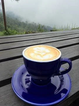 A cup of coffee on the table with mountain background Stock Photos