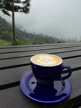 A cup of coffee on the table with mountain background Stock Photos