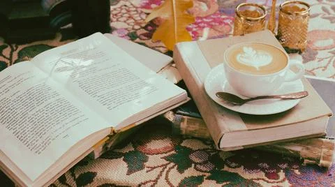 A cup of coffee on the table with notebook-vintage filter Stock Photos