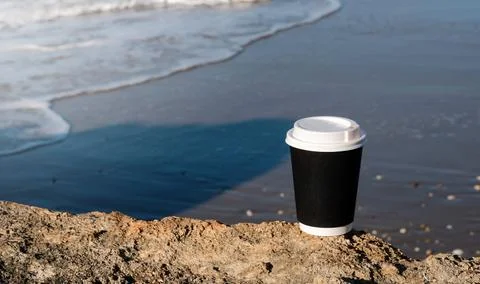Cup of coffee on a table over blue sky and empty sea beachside. Summer holiday Stock Photos