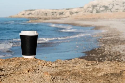 Cup of coffee on a table over blue sky and empty sea beachside. Summer holiday Foto stock
