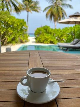 Cup of coffee on a table by the pool Stock Photos