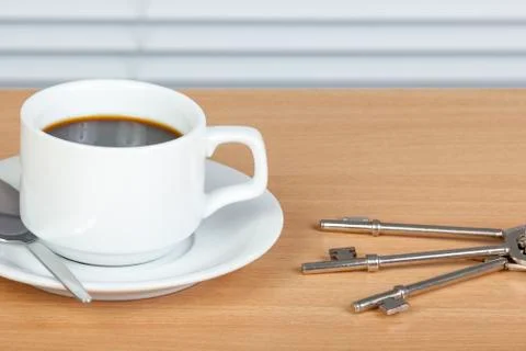 Cup of coffee on table with a set of keys Stock Photos
