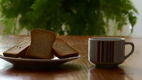 A cup of coffee on a table with toast beside it Stock Footage 230464847