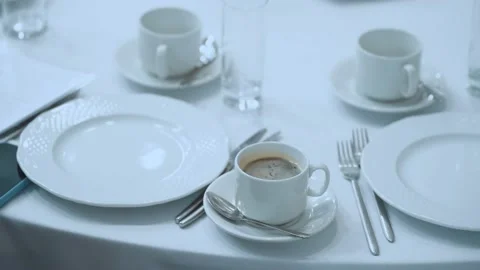 A cup of coffee on the table, a white cup with coffee on a white table Stock Footage 219963089