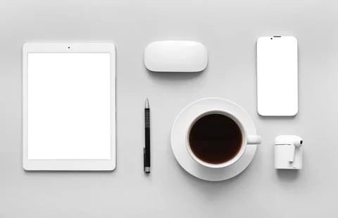 Cup of coffee, tablet computer and mobile phone on grey background Stock Photos