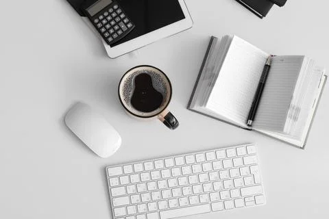 Cup of coffee with tablet computer, keyboard and stationery on white backgrou Stock Photos