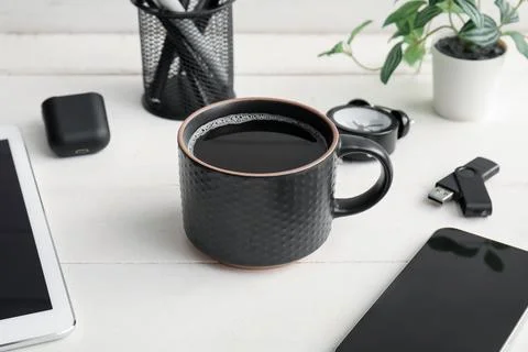 Cup of coffee with tablet computer, mobile phone and earphones on white woode Stock Photos