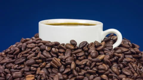 Cup of coffee on top of coffee beans, close up rotation Video stock 89855998