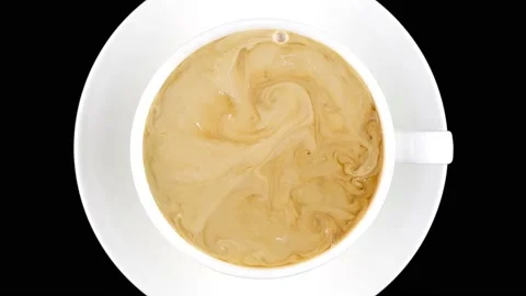 Cup of coffee top view. Hot cream is poured into coffee and turned into a beauti Stock Footage 146155030