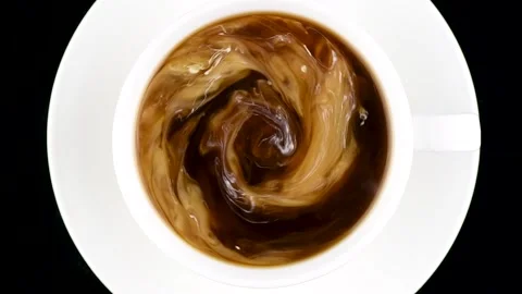 Cup of coffee top view. Hot cream is poured into coffee and turned into a beauti Stock Footage 146171608