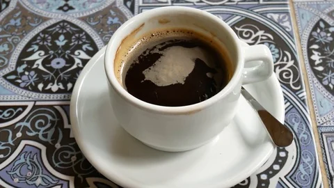 A cup of coffee is a top view. In the mug, the foam from the coffee is spinning. Stock Footage