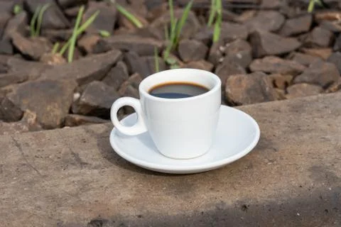 A cup of coffee on the train tracks Stock Photos
