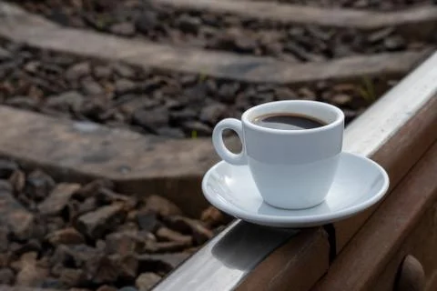 A cup of coffee on the train tracks Foto stock