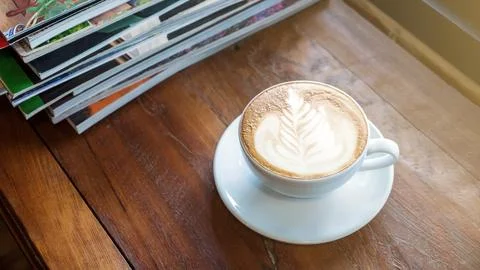 A cup of coffee was put in a stack of a book. Stock Photos