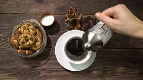 A cup of coffee into which milk is poured by a woman's hand. Morning coffee. Stock Footage 164143003