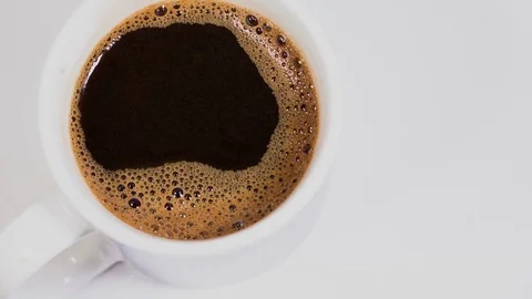 Cup of coffee on a white background with rotation, top view Stock Footage 74731009