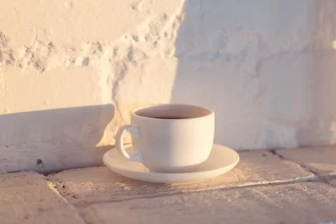 Cup of coffee on white brick background Stock Photos