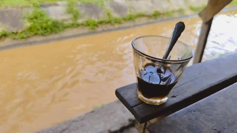 A cup of coffee on a wooden table by the river Stock Footage 334122335