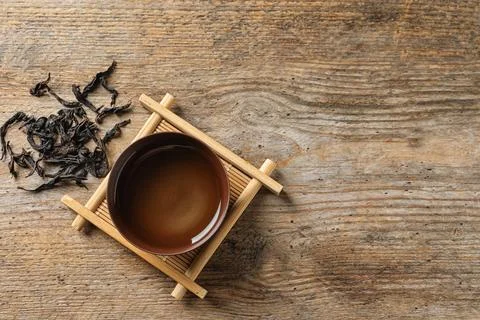 Cup of Da Hong Pao oolong and tea leaves on table, top view with space for te Stock Photos