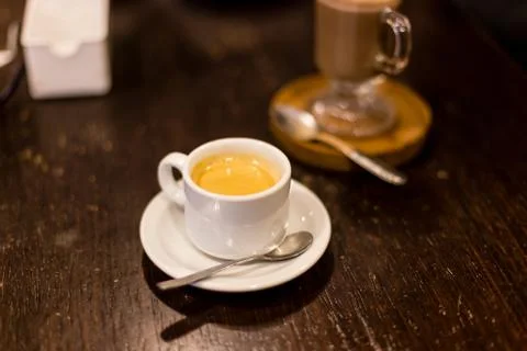 Cup of espresso, viewed from side, red cup, straw table Stock Photos