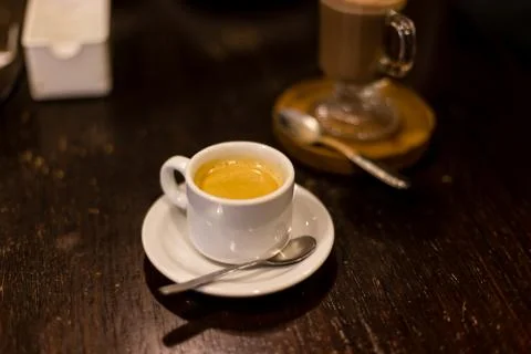 Cup of espresso, viewed from side, red cup, straw table Foto stock