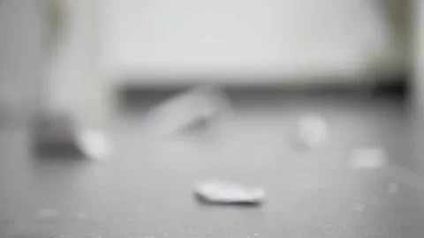 A cup falls to the floor from the table, breaks into many pieces. Stock Footage 229718444