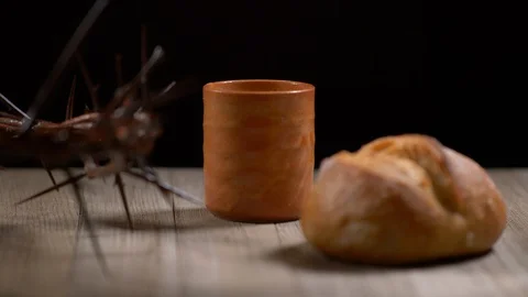Cup filled with wine surrounded by Jesus crown of thorns and Bread. Wine Stock Footage 128554727